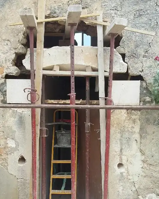 Pose de pierres de taille sous le linteau.